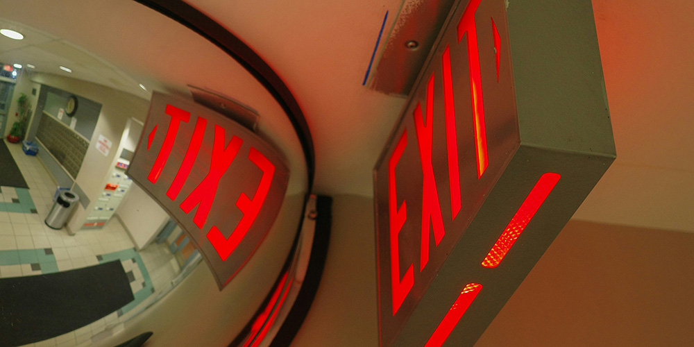 Red Illuminated Exit Sign and Reflection